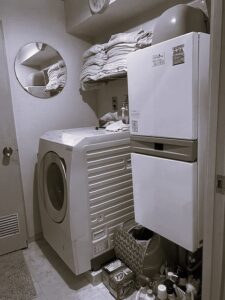 練馬区のH様邸では家具屋による吊戸の設置が行われていました。 74㎝の洗濯機パンを使うので、上部に75㎝幅のオープン棚収納を設けました。 簡単なオープン棚や既製品でも良さそうな場所にわざわざ造作家具を使ったのには理由があります。 もともとこちらのお宅は洗濯機の上にメッシュのオープン棚が1枚あり、そこにフェイスタオルを平置きしてたくさん積んでお使いでした。 というのも、H様は手を洗ったら都度新しいタオルを使う習慣があり（ですのでタオル掛けは必要ありませんでした）、タオルを沢山お使い、かつすぐに手に取れるようオープンな状態が良かったのです。 棚板ではタオルを積んだ時にずれて雑多に見えがちなこと、そしてそれまでは足元に置いて使われていた洗剤も置けるように、ハコ型が良いと思いました。 さらに梁下ということで寸法の制限もあり、わざわざ造作にしたわけです。 前もって伝えておいた形で造ってきてくれ、現場では取付けのみ。 あっという間に取付け完了、ついでと言ってはなんですが、隣のトイレの吊戸棚（こちらは既製品）も取付けしてもらいました。 ささやかな場所のささやかな工夫ですが、生活の中で満足感に大きな差があるのでは…と思っています。