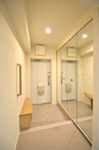 練馬区マンションリノベーション　玄関　照明　人感センサー　壁　器具付き　鏡に反射　影